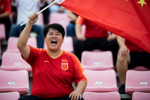 足球比赛看台上球迷挥舞旗帜，为球队加油助威